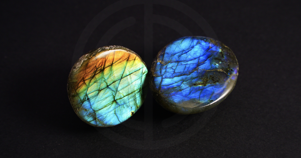 Two labradorite gemstones on dark background
